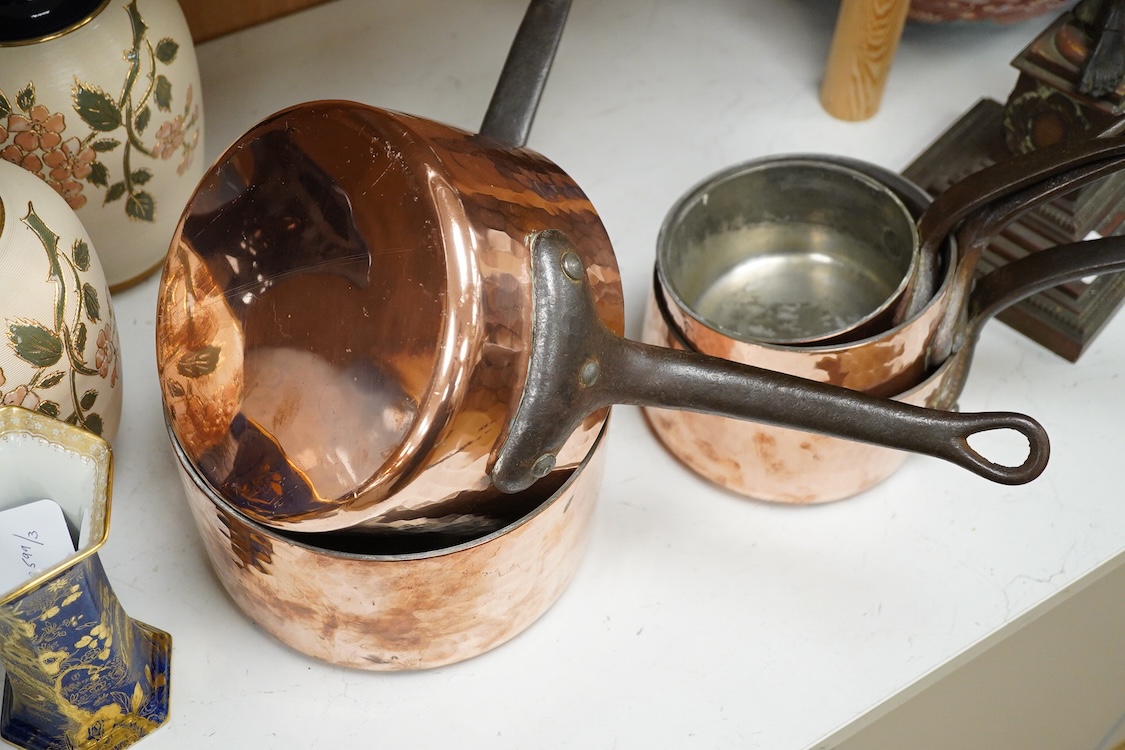 A set of five graduated hammered copper saucepans, largest 37cm in length